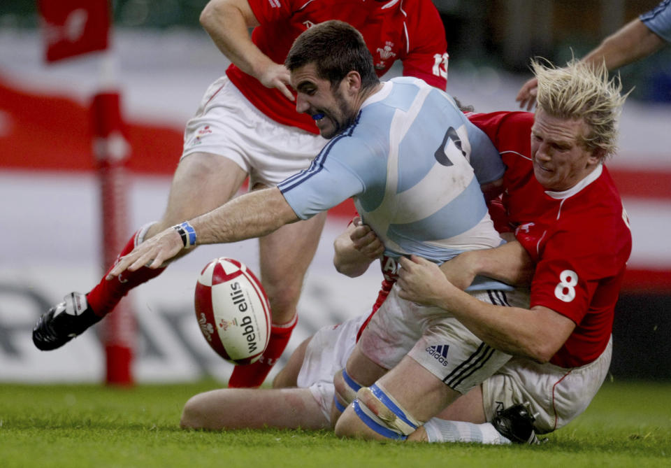 FILE - Argentina's Juan Martin, left, is tackled by Wales' Alix Popham during their rugby union international match at the Millennium Stadium in Cardiff, Wales, on Aug. 18, 2007. The Rugby World Cup will take place to the backdrop of a concussion lawsuit that has similarities to one settled by the NFL in 2013 at a likely cost of more than $1 billion. (AP Photo/Matt Dunham, File)