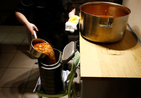 A chef of Caffe Italia restaurant pours soup into a portable container as part of a charity program to help homeless people in St. Petersburg, Russia November 28, 2018. REUTERS/Anton Vaganov