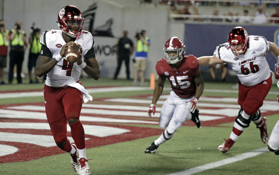 Louisville quarterback Jawon Pass (4) looks for a receiver as Alabama defensive back Xavier McKinney (15) gives chase during the first half of an NCAA college football game, Saturday, Sept. 1, 2018, in Orlando, Fla. (AP Photo/John Raoux)