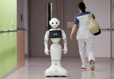 A nurse walks by new recruit "Pepper" the robot, a humanoid robot designed to welcome and take care of visitors and patients, at AZ Damiaan hospital in Ostend, Belgium June 16, 2016. REUTERS/Francois Lenoir