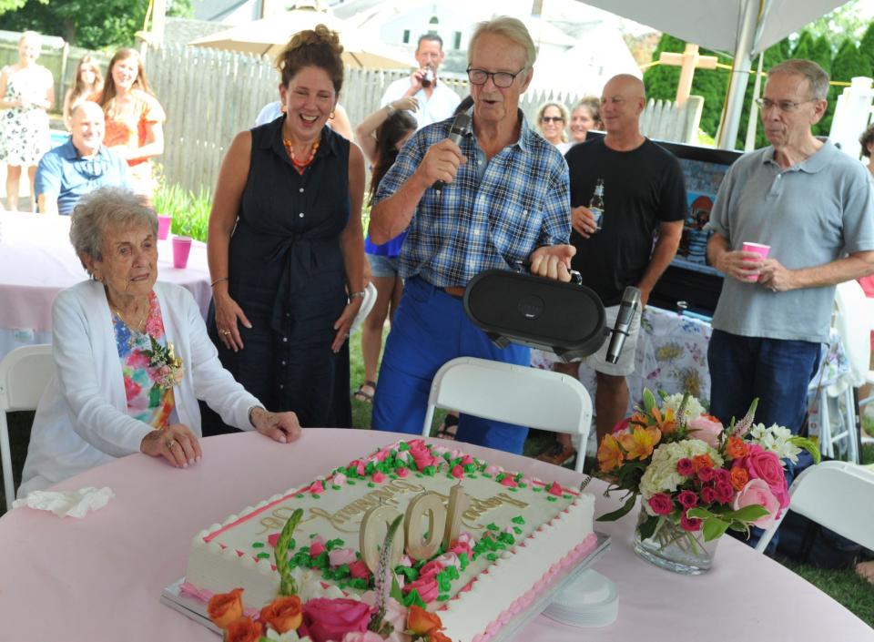 Alan Sharp, center, leads the singing of "Happy Birthday" to his mother, Jo Sharp, seated left, as her family gathers at her Braintree home to celebrate her 100th birthday.