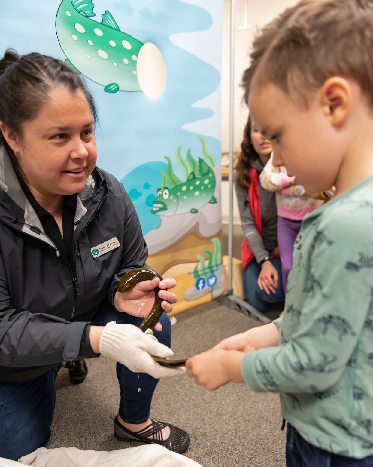 Arlo Dodd touches a sea lamprey during the Earth Plus Expo, presented by Earth Week Plus, at the Cheboygan Area Public Library on Saturday, April 20, 2024.