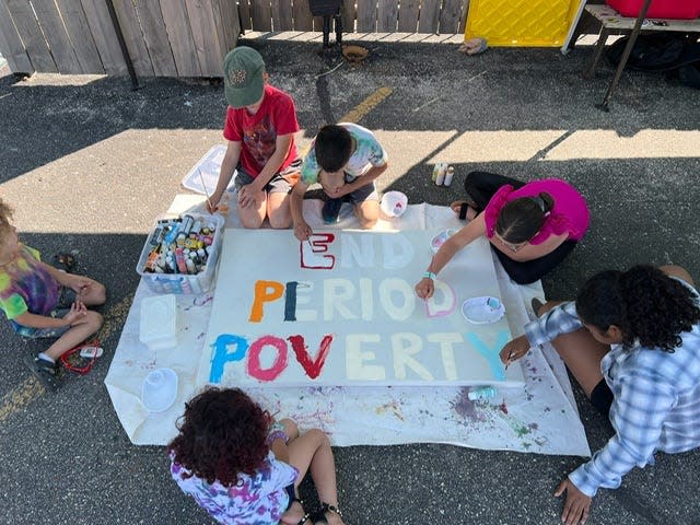 Children paint a poster at a 2023 period party in Milwaukee. The period party collected period products and raised money to help end period poverty.
