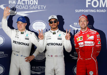 Formula One F1 - Japanese Grand Prix 2017 - Suzuka Circuit, Japan - October 7, 2017. Mercedes' Lewis Hamilton of Britain celebrates pole position in qualifying with Valtteri Bottas of Finland and Ferrari's Sebastian Vettel of Germany. REUTERS/Toru Hanai