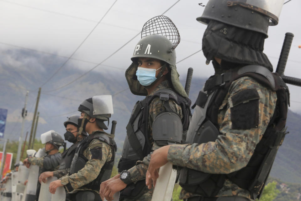 Guatemalan soldiers stands guard at a police checkpoint on the Motagua River to stop the advance of Honduran migrants in Zacapa, Guatemala, Tuesday, Jan. 19, 2021. A once large caravan of Honduran migrants that pushed its way into Guatemala last week had dissipated by Tuesday in the face of Guatemalan security forces. (AP Photo/Oliver de Ros)