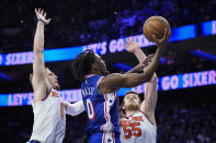 Philadelphia 76ers' Tyrese Maxey, center, goes up to shoot against New York Knicks' Donte DiVincenzo (0) and Isaiah Hartenstein (55) during the second half of Game 6 in an NBA basketball first-round playoff series, Thursday, May 2, 2024, in Philadelphia. (AP Photo/Matt Slocum)