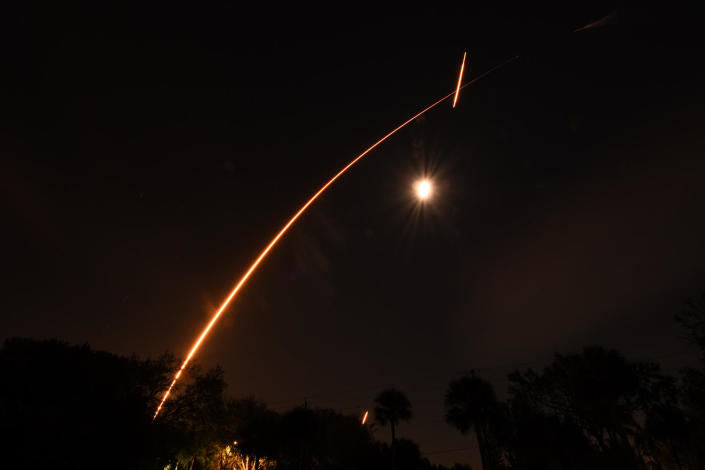 A time exposure captures the exhaust plume of a SpaceX Falcon 9 rocket as it streaked toward space Monday night, passing above the moon as viewed from nearby Merritt Island, Florida. The rocket's first stage carried out two engine firings as it executed a successful return-to-launch-site landing. / Credit: William Harwood/CBS News