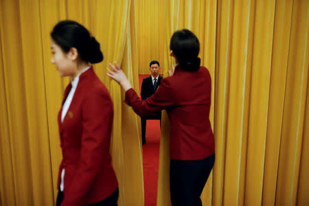 A security officer keeps watch behind a curtain on the second day of the 19th National Congress of the Communist Party of China at the Great Hall of the People in Beijing, October 19, 2017. REUTERS/Thomas Peter