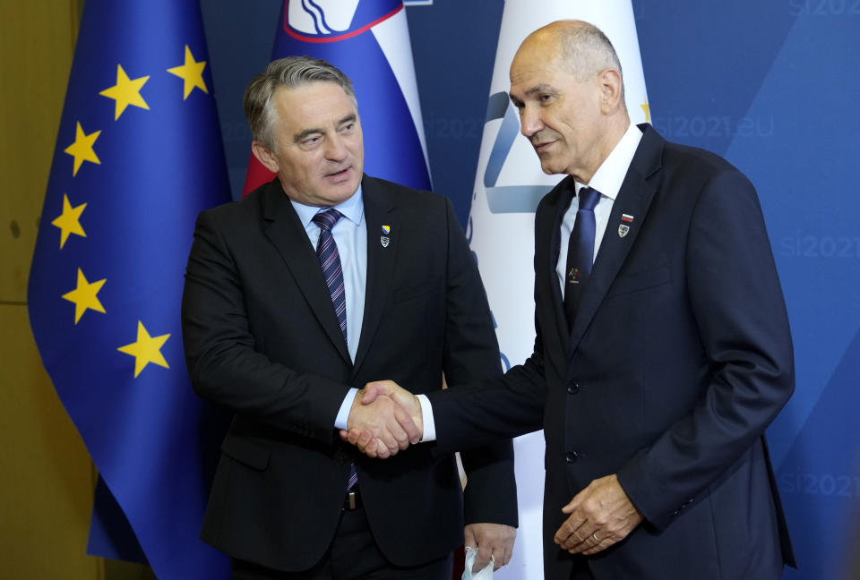 Chairman of Bosnia and Herzegovina's tripartite presidency Zeljko Komsic, left, is greeted by Slovenia's Prime Minister Janez Jansa during arrivals for an EU summit at the Brdo Congress Center in Kranj, Slovenia, Wednesday, Oct. 6, 2021. European Union leaders are gathering Wednesday to reassure six countries in the Balkans region that they could join the trading bloc one day if they can meet its standards but are unlikely to give any signal even about when they might advance in their quests. (AP Photo/Darko Bandic)