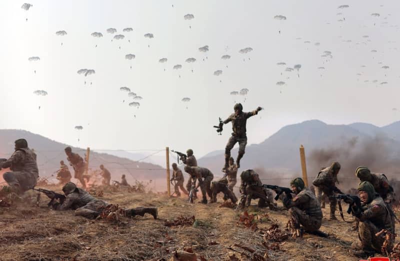 A picture released by the North Korean State News Agency (KCNA) on 16 March 2024 shows North Korean paratroopers taking part in military drills of air-borne units of the Korean People's Army, attended by leader Kim Jong Un and his daughter. -/yonhap/dpa