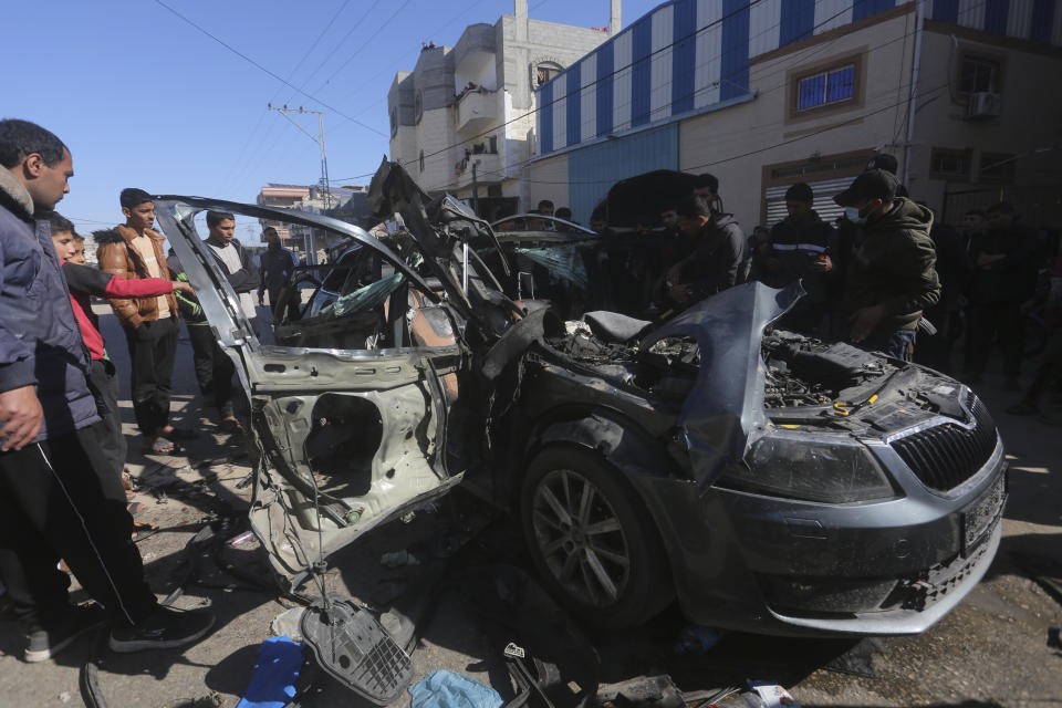 Palestinians look at a car targeted by an Israeli airstrike in Rafah, Gaza Strip, Sunday, Jan. 7, 2024. Two journalists were killed in the strike, Hanza Dahdouh, who worked for Al Jazeera, and a freelance journalist, Mustafa Thuria (AP Photo/Hatem Ali)