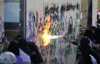 Women attack Mexico's Revolution Monument during a march to commemorate International Women's Day and to protest against gender violence, in Mexico City, Monday, March 8, 2021. (AP Photo/Rebecca Blackwell)