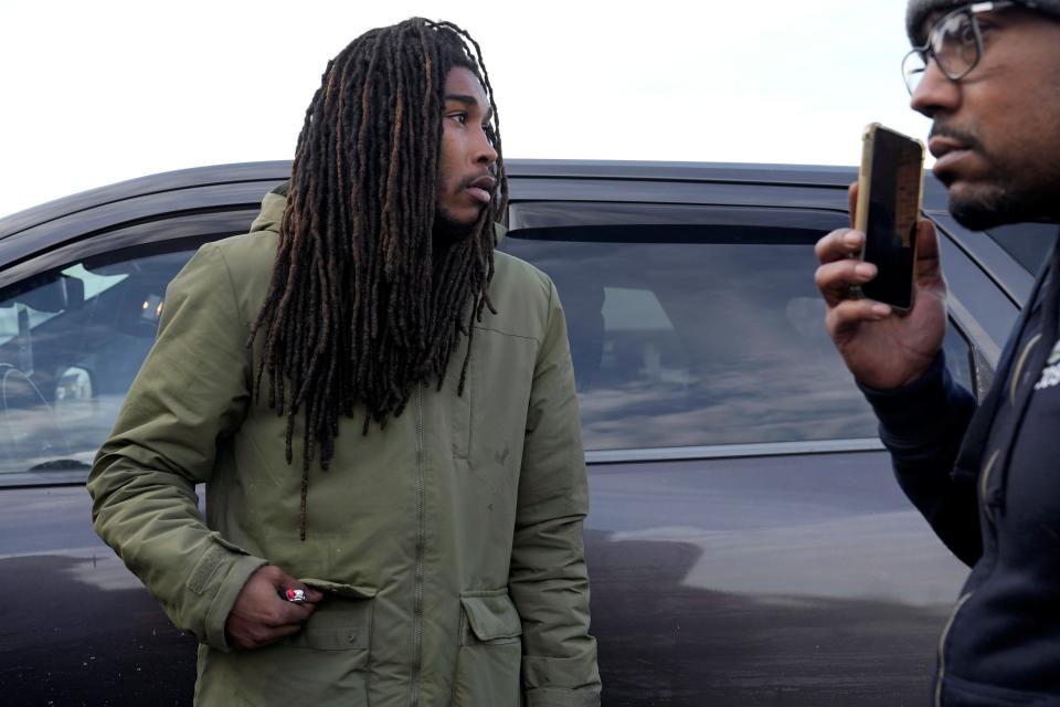 Lachez Thomas, left, stands in a gas station parking lot on Brandt Pike with Dion Green at right, as family members searched Dayton last month search for Thomas' five-month-old son Kason Thomas, who remained missing until Dec. 22.