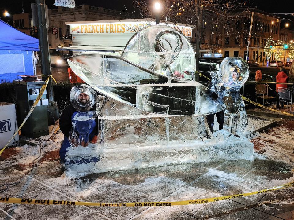 Ice carvers from DiMartino Ice Company pose for photos after completing this giant ice sculpture, which depicts an alien in a spaceship, on the northwest quadrant of the square during the opening night of IceFest in Chambersburg on Thursday, Jan. 27, 2022.