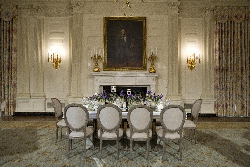 A view of the table setting during a press preview in the State Dining Room of the White House in Washington, Monday, Feb. 10, 2014, ahead of Tuesday's State Dinner for French President François Hollande. First lady Michelle Obama's office gave the media, and by extension, the public, a peek at the elegant place settings, colorful flower arrangements and other details of the soiree. At least part of the evening's event will take place in a huge white tent going up on the South Lawn. (AP Photo/ Evan Vucci)