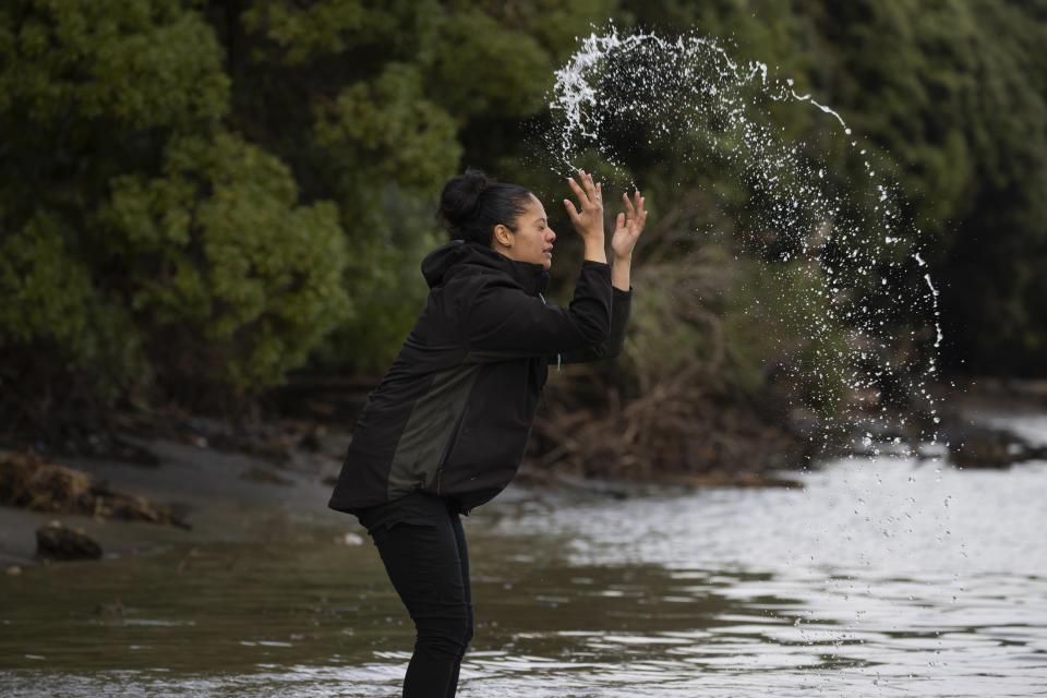 Ngahuia Twomey-Waitai, 28, reaches into New Zealand's Whanganui River to ritually splash water on herself on June 17, 2022. “I tend to come down here quite often to cleanse myself, especially when I’m going through some big, huge changes in my life, regardless of them being good or bad," she says. “The river always makes things better for me." “Just being down here gives me a huge smile and brings me at peace with myself and my life.” (AP Photo/Brett Phibbs)