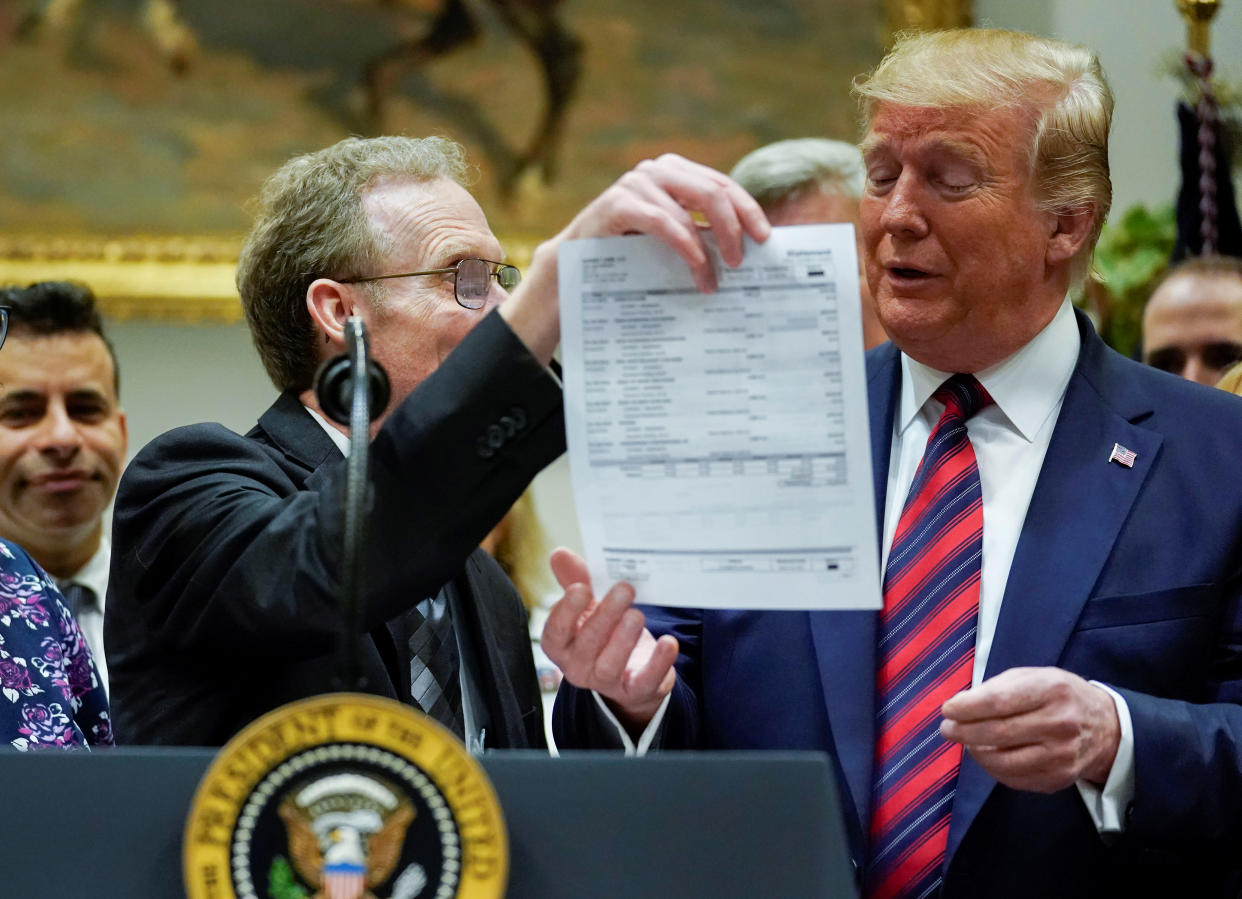 Dr. Paul Davis of Findlay, Ohio holds up a large surprise medical bill that he received for U.S. President Donald Trump to see during an event centered on a proposal to end surprise medical billing in the Roosevelt Room at the White House in Washington, U.S., May 9, 2019. REUTERS/Jonathan Ernst