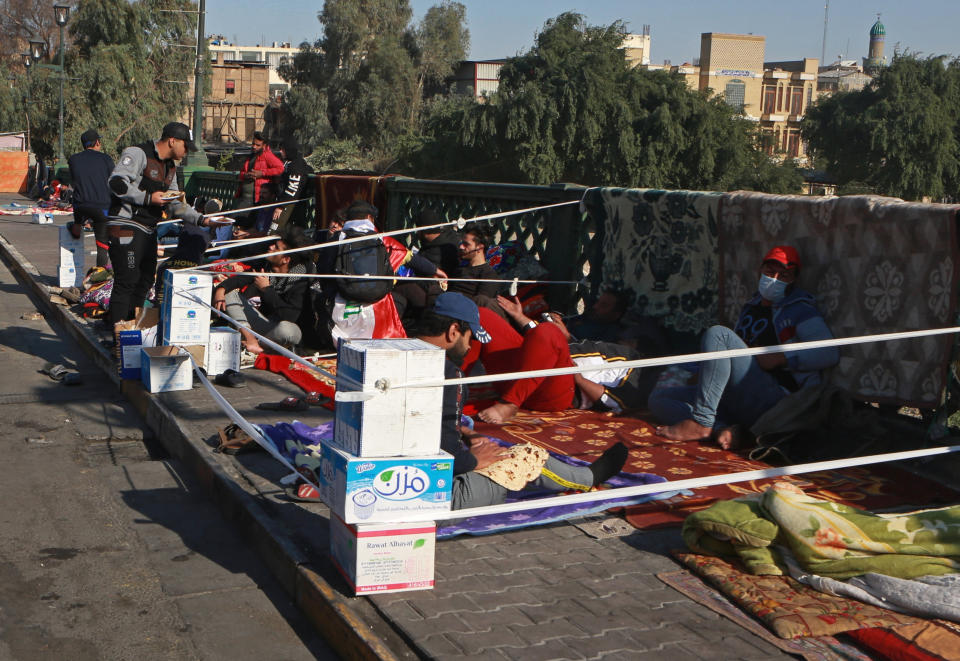 Anti-government protesters stage a sit-in on the Ahrar Bridge, in Baghdad, Iraq, Wednesday, Nov. 20, 2019. Iraqi security officials said Wednesday that at least 27 protesters have been wounded in renewed clashes overnight in central Baghdad. (AP Photo/Khalid Mohammed)