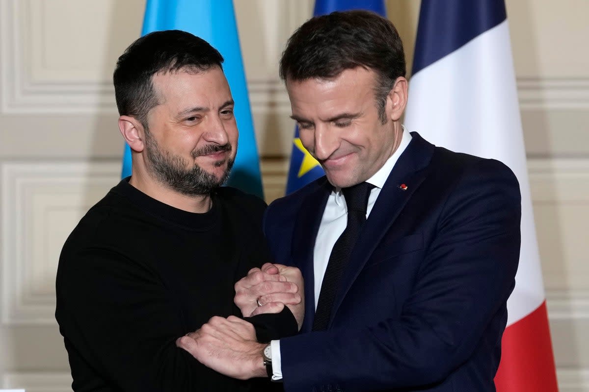 Ukrainian President Volodymyr Zelenskyy, left, and French President Emmanuel Macron shake hands after a press conference in February  (AP)