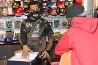 <p>T.I. spreads holiday cheer by gifting a student from Next Level Boys Academy clothes and shoes during Harris Community Works Holiday Caravan at DLTR on Monday in Atlanta.</p>