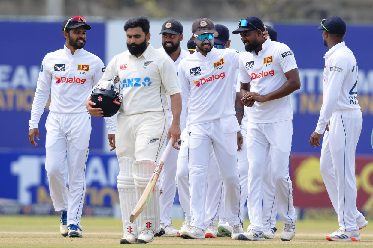 New Zealand's Ajaz Patel, holding his bat, walks in front of Sri Lanka's players as they leave the field after Sri Lanka won the first cricket test match against New Zealand in Galle, Sri Lanka, Monday, Sept. 23, 2024. (AP Photo/Viraj Kothalawala)