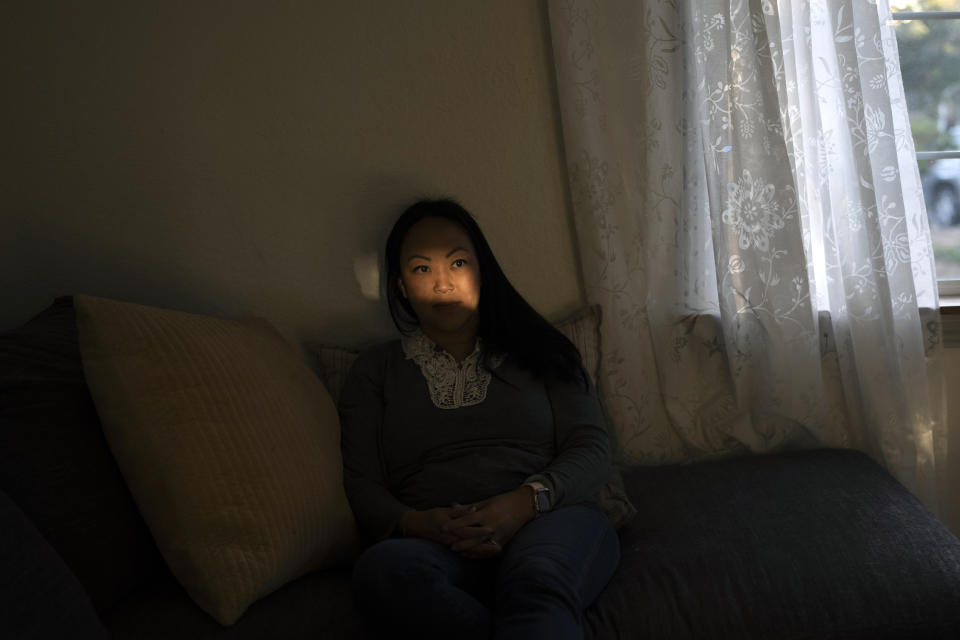 I-Ting Quinn, a mother of two young children, pauses for photos as a shaft of light falls on her face in Concord, Calif., Wednesday, Nov. 1, 2023. A year before Quinn's son was old enough for kindergarten, she and her husband had the option to enroll him in “transitional kindergarten” — a program offered for free by California elementary schools for some 4-year-olds. Instead, they kept their son, Ethan, in a private daycare center in Concord. (AP Photo/Jae C. Hong)