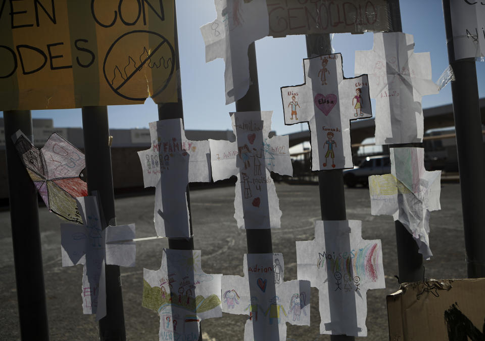 Esta fotografía del jueves 20 de abril de 2023 muestra cruces de papel con nombres de migrantes, pegadas en una reja de un centro de detención en el que fallecieron a consecuencia de un incendio que se inició en una de sus celdas el mes pasado, en Ciudad Juárez, México. Más de tres decenas de personas murieron. (AP Foto/Christian Chávez)