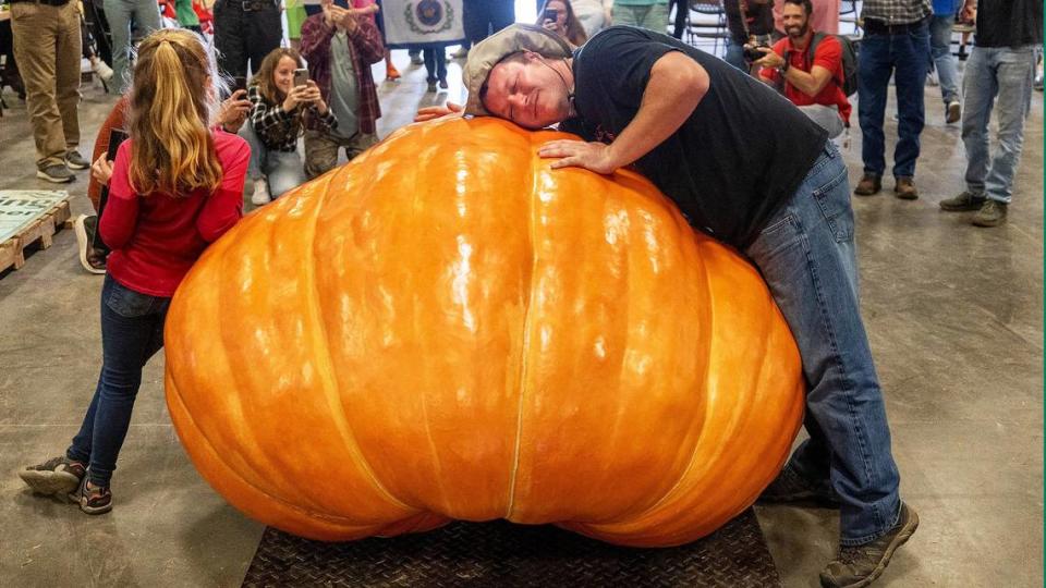 Chris Rodebaugh of Lewisburg, West Virginia, embraces his prize winning pumpkin, which weighed in at 1461 pounds, following the weigh-off for the giant pumpkin contest on Tuesday, October 11, 2022 at the Expo Center for the 2022 N.C. State Fair in Raleigh, N.C. Robert Willett/rwillett@newsobserver.com