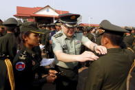 A Chinese army advisor (C) puts rank on Cambodian army graduates during a graduation ceremony at Army Institute in Kampong Speu province March 12, 2015. REUTERS/Samrang Pring