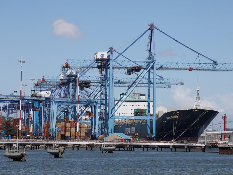 A container ship docked at Mombasa port, Kenya, with loading cranes in view.