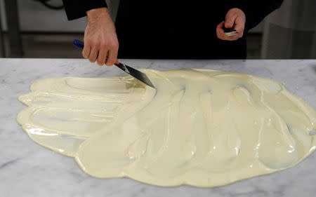 Nestle's Jan Kuendiger spreads white chocolate over a marble work surface in a kitchen at the company's Product Technology Centre in York, Britain, March 21, 2018. REUTERS/Phil Noble