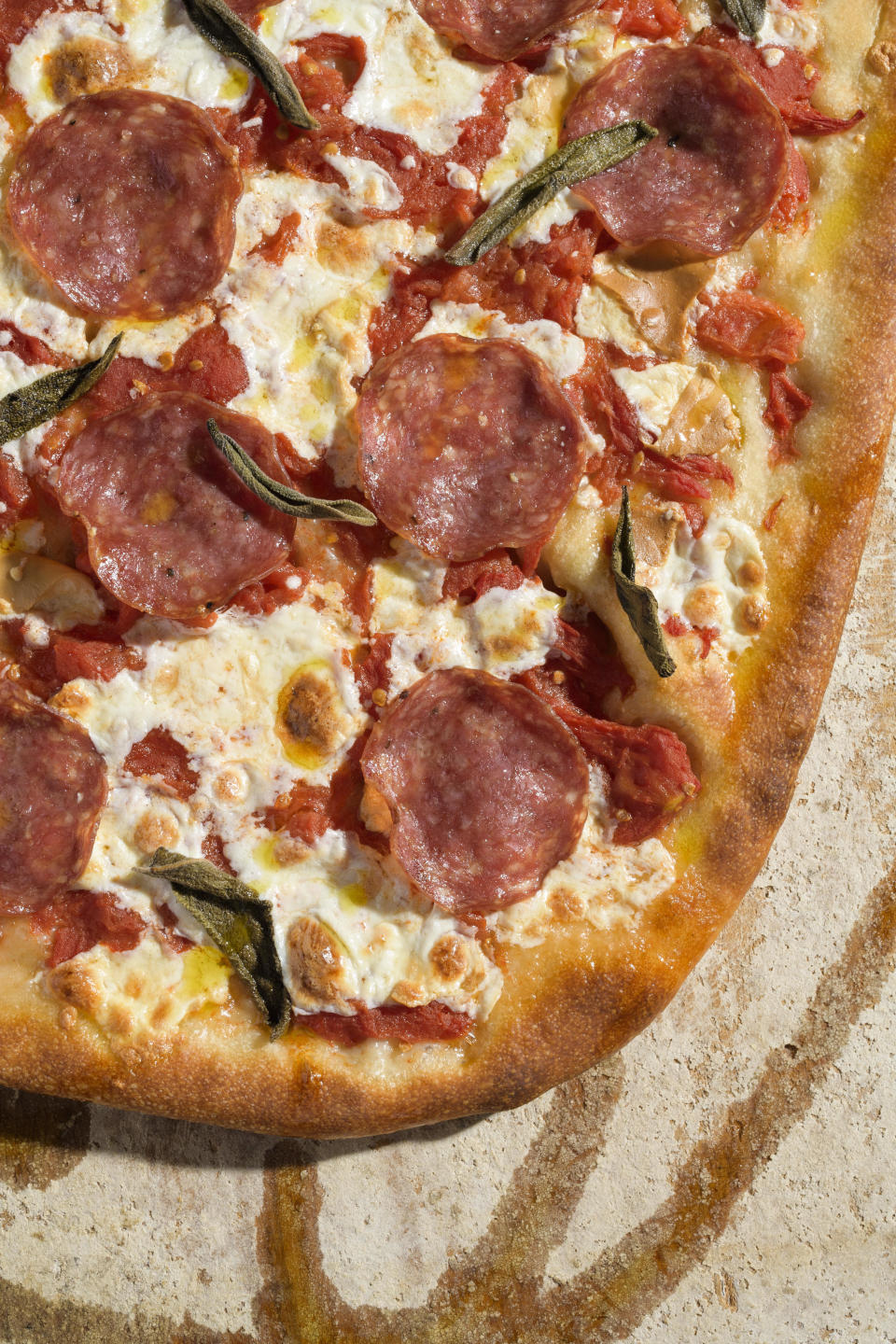 This image released by Milk Street shows a recipe for pizza with salami and smoked mozzarella. (Milk Street via AP)