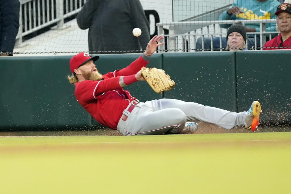Cincinnati Reds right fielder Jake Fraley (27) can't get to Atlanta Braves shortstop Orlando Arcia (11) foul ball during the second inning of a baseball game Friday, April 8, 2022, in Atlanta. (AP Photo/John Bazemore)