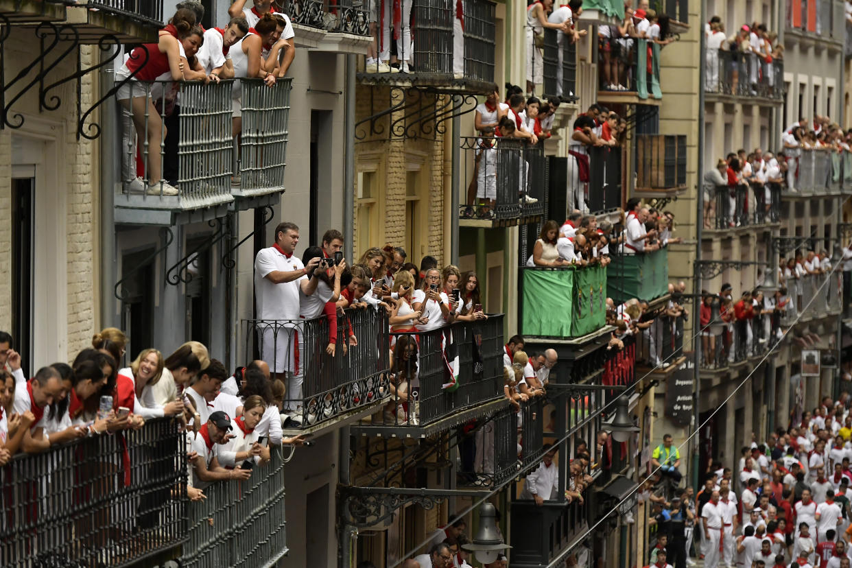 Viewers crammed on balconies above the street wait for the start of the running of the bulls.