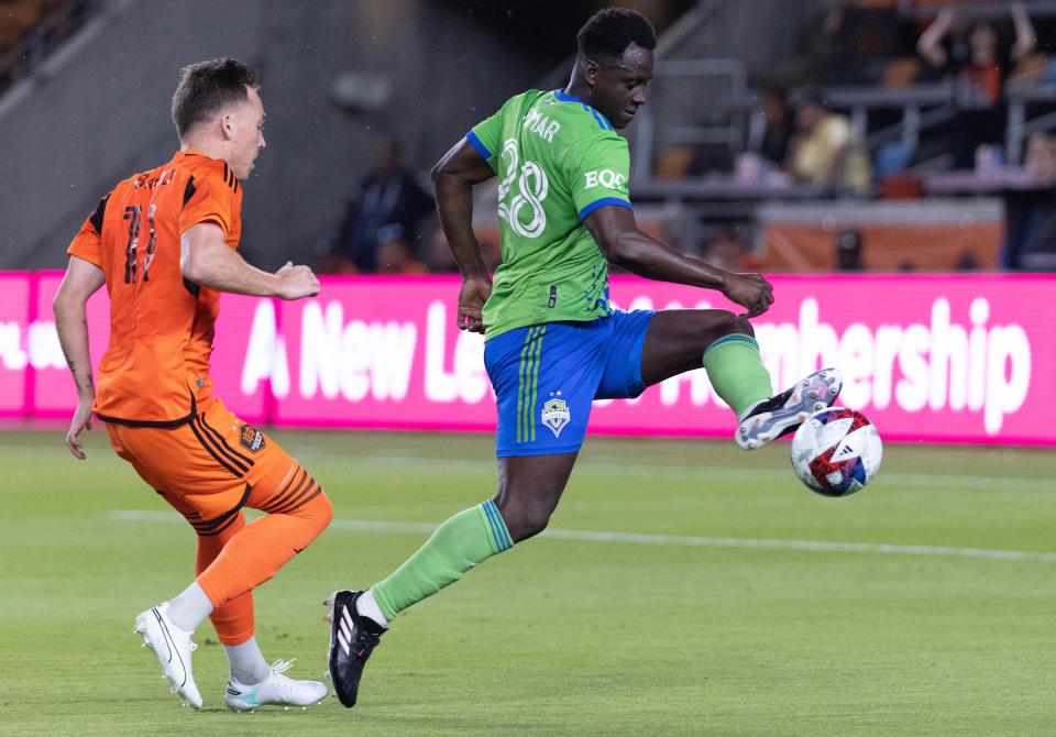 Seattle Sounders forward Yeimar Gomez, right, clears the ball away from Houston Dynamo FC forward Corey Baird during their match last Saturday. The Sounders are currently leading the Western Conference.