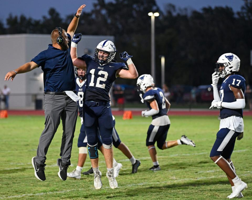 Parrish Community High School's new head football coach, Robert Dylan Clark celebrates the team's extra point with Gage Cameron (12). Parrish Community Bulls wins big 43-0 over the North Port Bobcats during a home game played at Parrish Community High School in Parrish, Friday night, August 25, 2023.