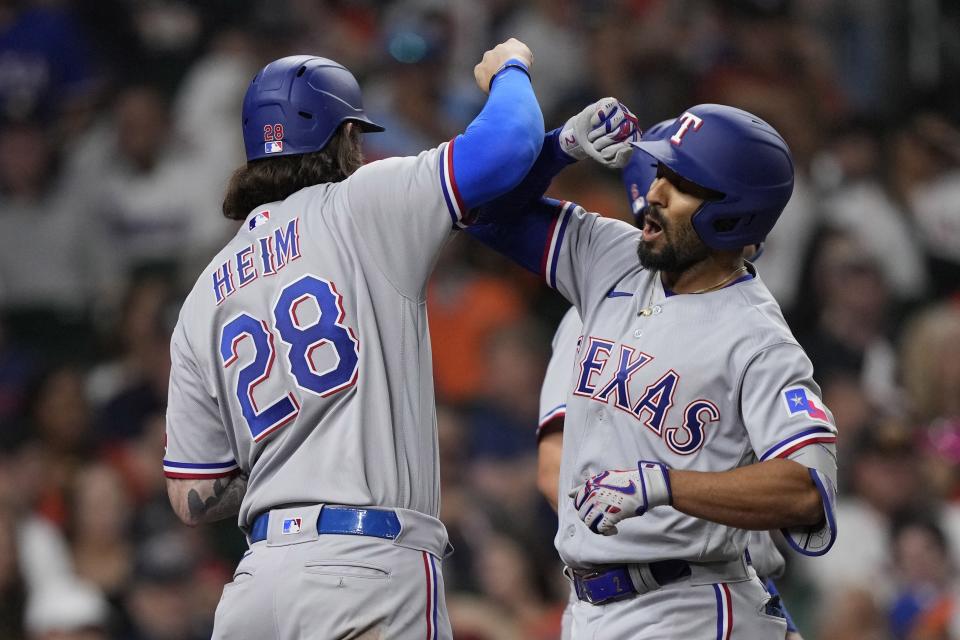 Texas Rangers' Marcus Semien, right, celebrates with Jonah Heim (28) after hitting a grand slam against the Houston Astros during the seventh inning of a baseball game Sunday, April 16, 2023, in Houston. (AP Photo/David J. Phillip)