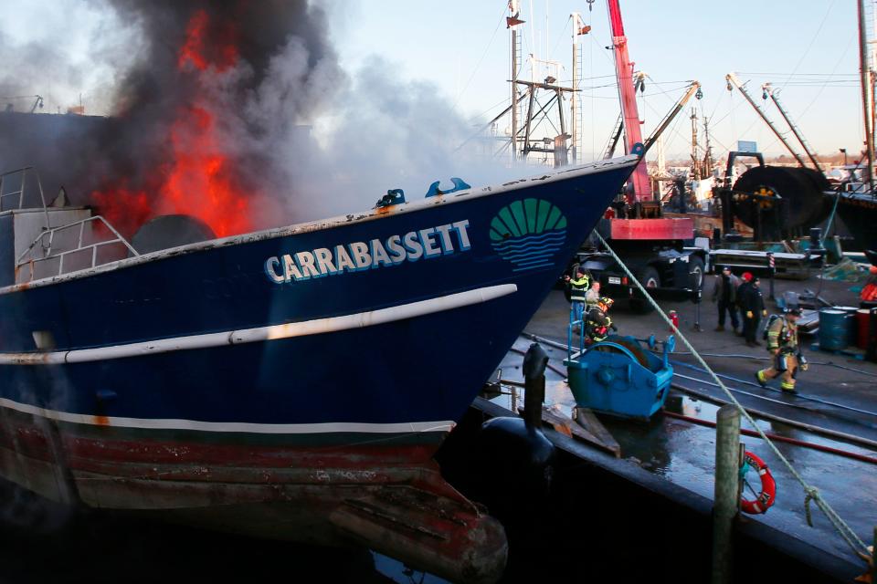 Fairhaven firefighters battle a fire that broke out Thursday morning inside the fishing boat Carrabassett, which was docked along Water Street in Fairhaven.