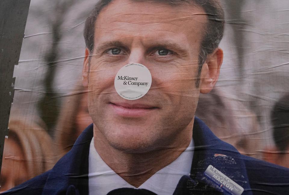 A Macron poster in Paris is defaced with a sticker describing him as the ‘president of the rich' (AP)