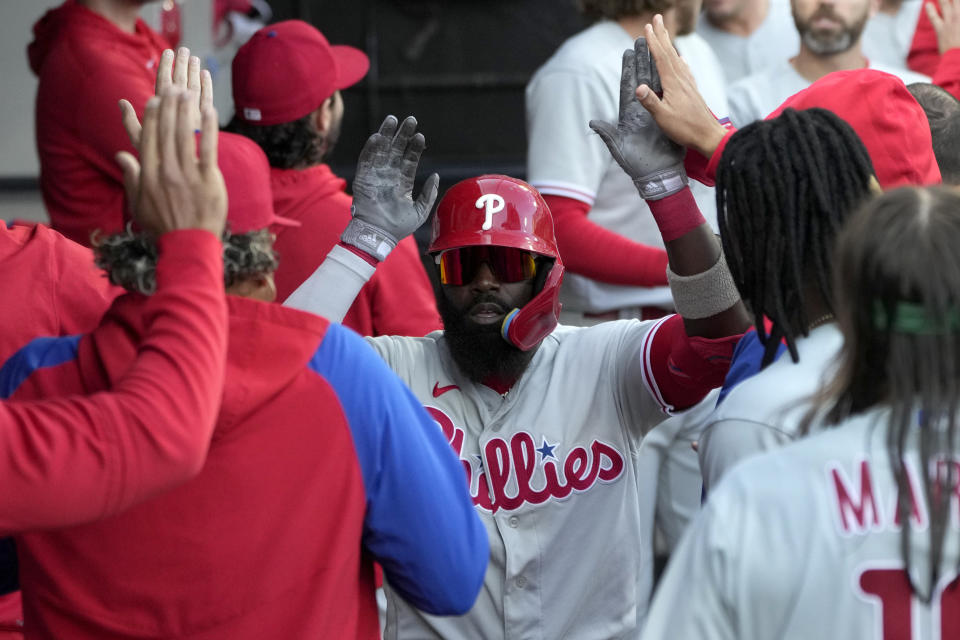 Philadelphia Phillies' Josh Harrison celebrates in the dugout after his two-run home run off Chicago White Sox relief pitcher Jimmy Lambert during the seventh inning in the first game of a baseball doubleheader Tuesday, April 18, 2023, in Chicago. (AP Photo/Charles Rex Arbogast)