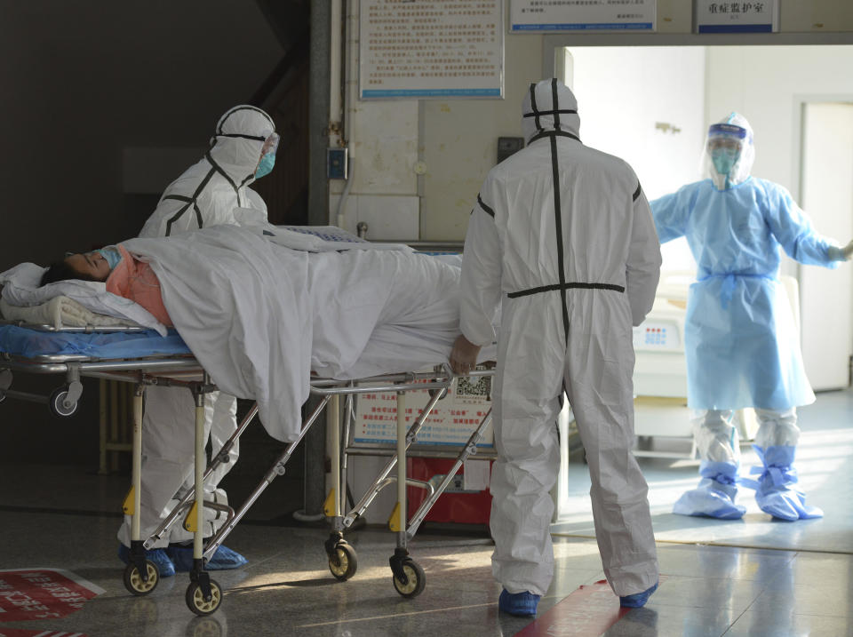 Personal médico, vestidos con trajes de protección, trasladan a un paciente afectado por un coronavirus a una zona de aislamiento en un hospital de Fuyang, en la provincia de Anhui, en el centro de China, el 1 de febrero de 2020. (Chinatopix via AP)
