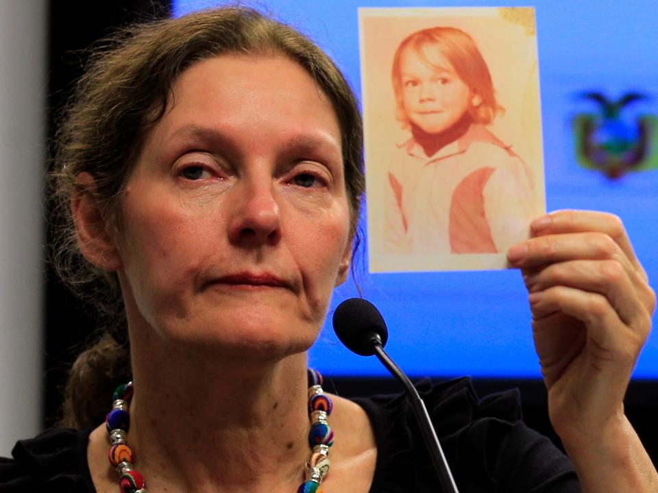 The mother of WikiLeaks founder Julian Assange, Christine Assange, holds up a picture of her son Julian when he was 4-years-old, during a press conference, after meeting with Ecuador's foreign minister in Quito, Ecuador, Monday, July 30, 2012.