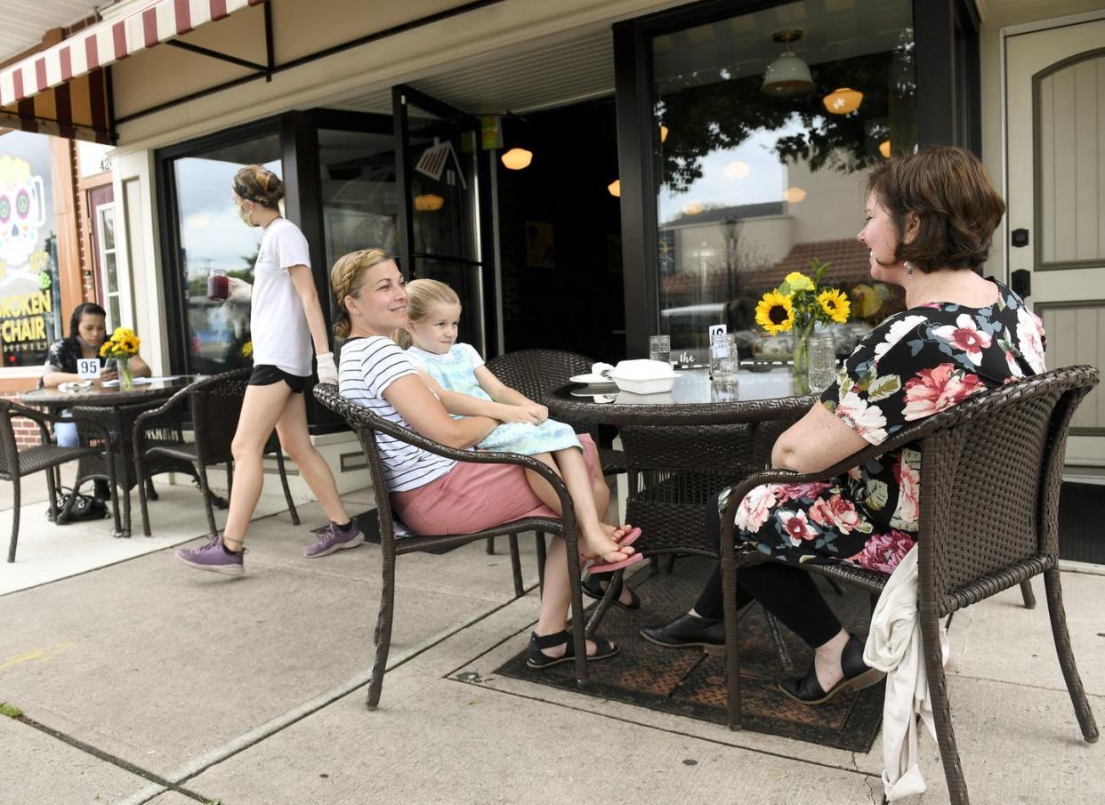 <span class="caption">Patrons eat outside at a small cafe in West Reading, Pennsylvania, as the community begins to reopen.</span> <span class="attribution"><a class="link " href="https://www.gettyimages.com/detail/news-photo/bambi-good-and-her-daughter-alaina-of-reinholds-talk-with-news-photo/1249265204" rel="nofollow noopener" target="_blank" data-ylk="slk:Ben Hasty/MediaNews Group/Reading Eagle via Getty Images;elm:context_link;itc:0;sec:content-canvas">Ben Hasty/MediaNews Group/Reading Eagle via Getty Images</a></span>