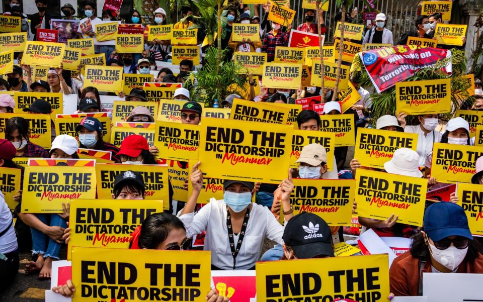 Myanmar protesters hold banners as they gather outside the US Embassy