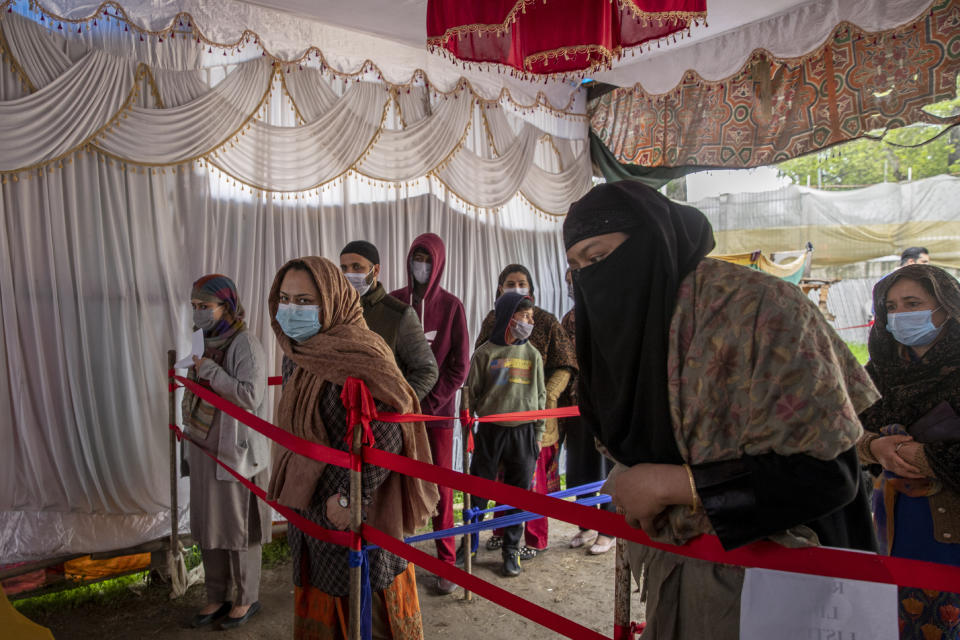 Kashmiris wait in queue to register themselves to test for COVID-19 in Srinagar, Indian-controlled Kashmir, Thursday, April 15, 2021. India's two largest cities imposed stringent restrictions on movement and one planned to use hotels and banquet halls to treat coronavirus patients amid a devastating surge that is straining a fragile health system. (AP Photo/ Dar Yasin)