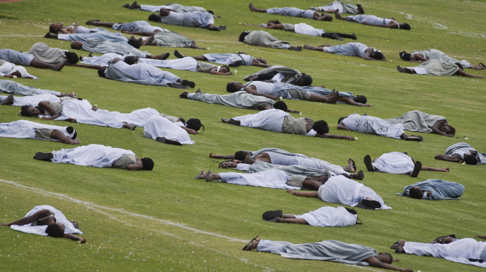 Performers re-enact the events at a public ceremony to mark the 20th anniversary of the Rwandan genocide, at Amahoro stadium in Kigali, Rwanda, Monday, April 7, 2014. Sorrowful wails and uncontrollable sobs resounded Monday as thousands of Rwandans packed the country's main sports stadium to mark the 20th anniversary of the beginning of a devastating 100-day genocide. (AP Photo/Ben Curtis)