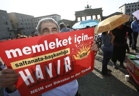 A man holds banner calling Turkish voters to vote "no" on the upcoming referendum as he attends an anti-Turkish President Tayyip Erdogan prostest in front of the Brandenburg Gate in Berlin, Germany, April 1, 2017. REUTERS/Fabrizio Bensch