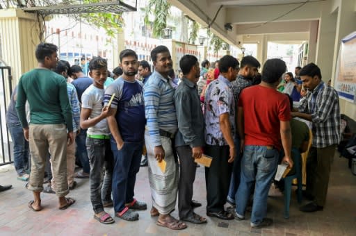 People queue to receive the oral cholera vaccine from health workers in Dhaka