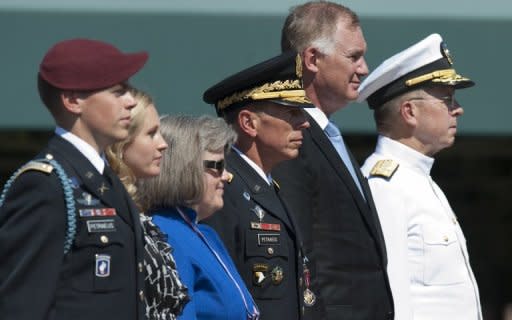 US Army General David Petraeus (3rd R) stands alongside his family, including children Stephen (L) and Anne (2nd R), and wife Holly (3rd L), as well as Admiral Mike Mullen (R), Chairman of the Joint Chiefs of Staff, and Deputy Secretary of Defense William Lynn (2nd R), during an Armed Forces Farewell Tribute and Retirement Ceremony in honor of Petraeus in Arlington, Virginia, in 2011