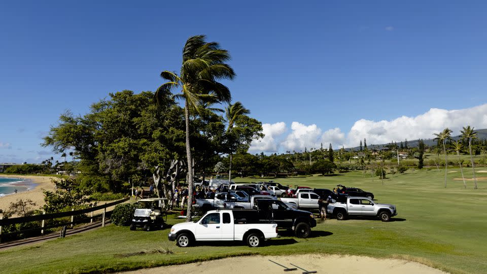Trucks parked on the fifth hole fairway of the Royal Ka'anapali golf course, waiting to be loaded up with supplies. - Paul Murphy/CNN